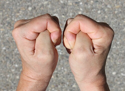 両手の親指を握って幸運を祈るポーズ