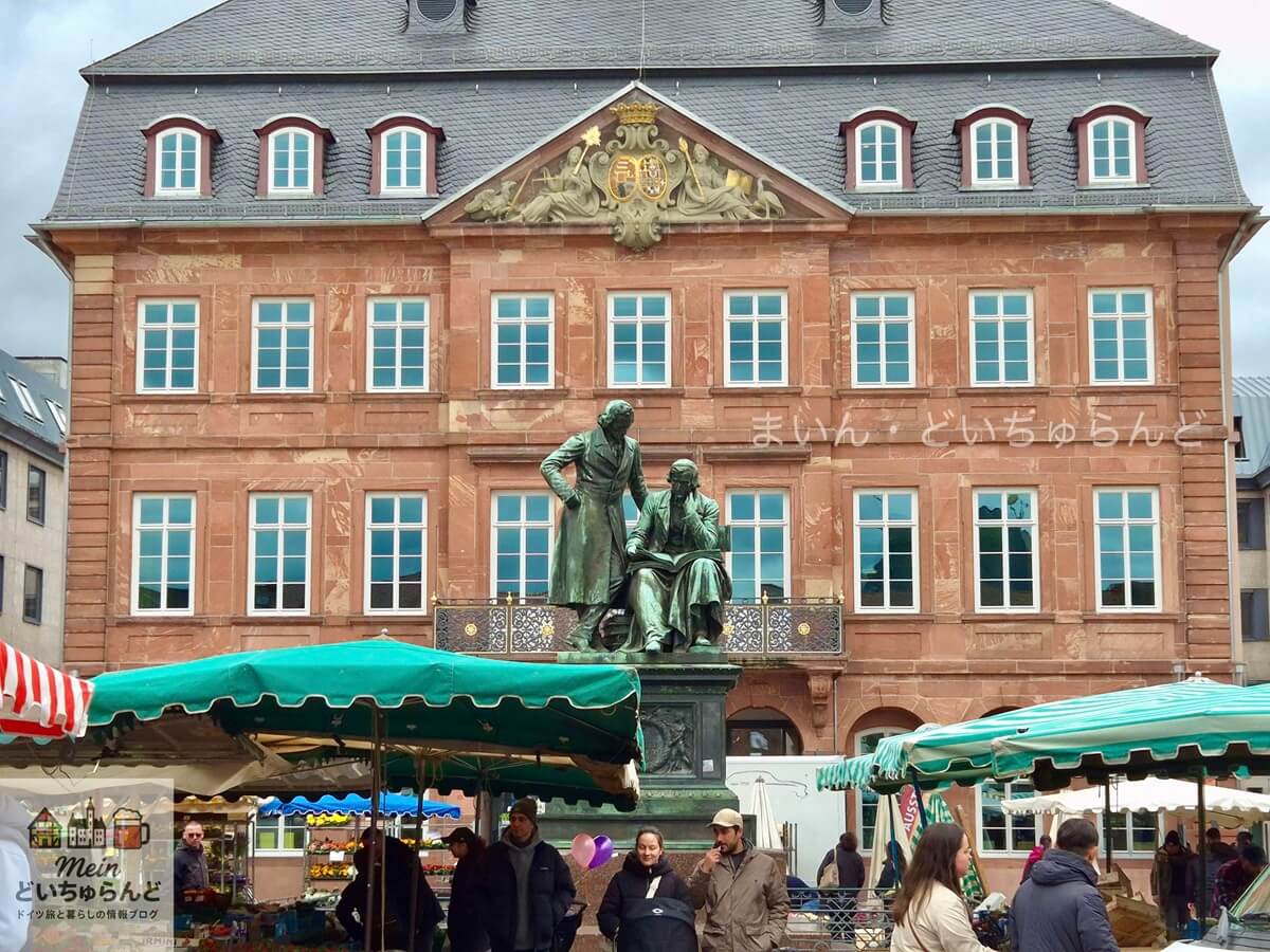 ハーナウ マルクト広場に立つグリム兄弟の像と週市