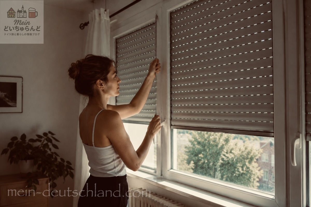 外付けシャッター式の雨戸を閉める女性